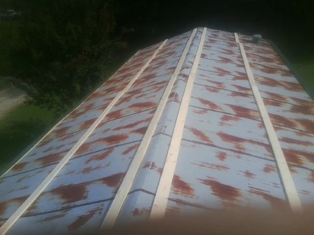 Rusted metal roof panels with new wood purlins before replacement — Storm Damage Roof Repair in Constantia by Roofing Brothers