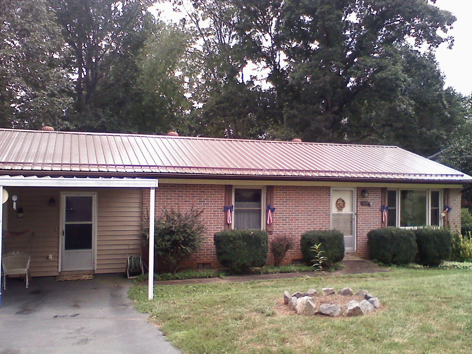 Bronze metal roof and carport on a brick ranch home — Roof Repair work by our crew in Constantia